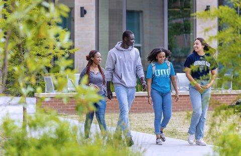 A group of 学生 walking in front of Owens House residence hall